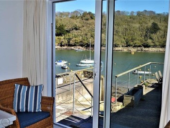 THE SITTING ROOM HAS PATIO DOORS LEADING OUT ONTO A PATIO WITH DELIGHTFUL VIEWS OF THE RIVER