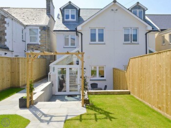 ATTRACTIVE REAR GARDEN WITH STEPS DOWN TO PATIO AND ENTRANCE